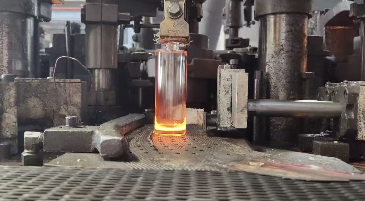 Glass bottle freshly formed — still glowing from the heat in the forming machine